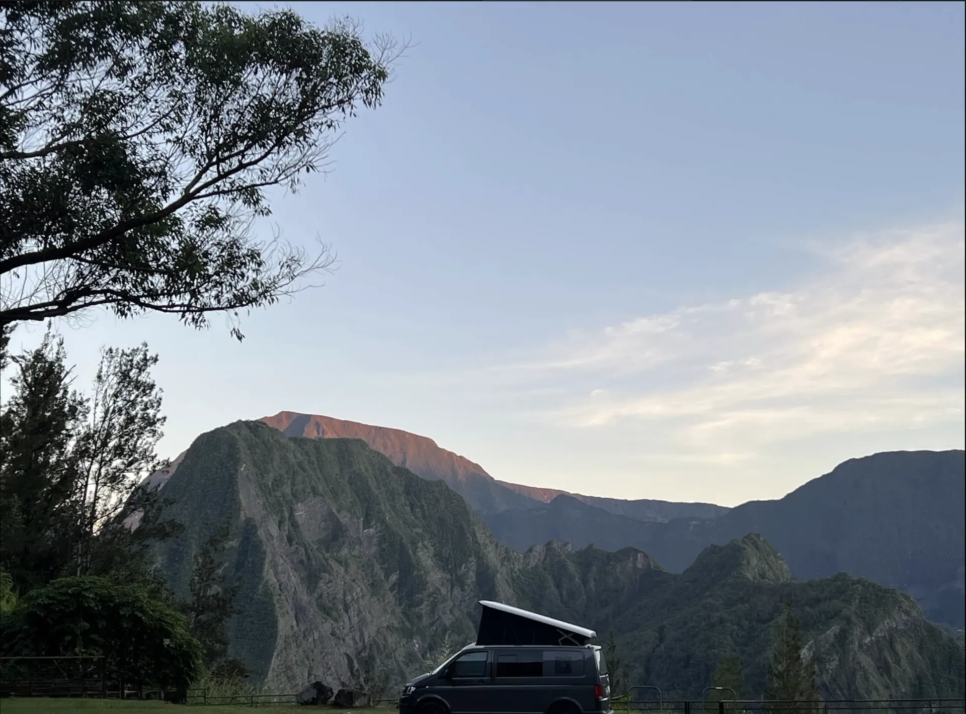 Van aménagé à La Réunion sur un plateau avec vue sur les montagnes au lever du jour