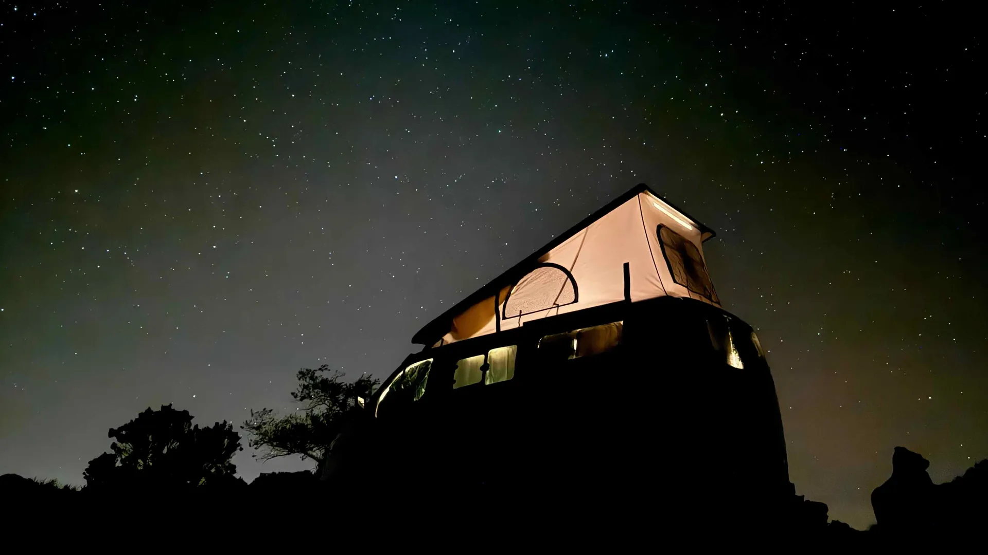 Van aménagé La Réunion en bivouac de nuit, toit relevable éclairé sous un ciel étoilé